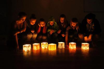 Students are  lighting lanterns with photos of LWM cases, LWM in Poland, XII 2012