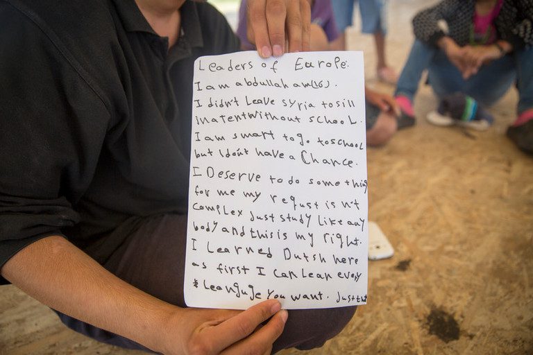 16-letni Abdullah z Syrii, pisze wiadomość do europejskich przywódców z obozu Nea Kavala. © Amnesty International (Photo: Richard Burton)