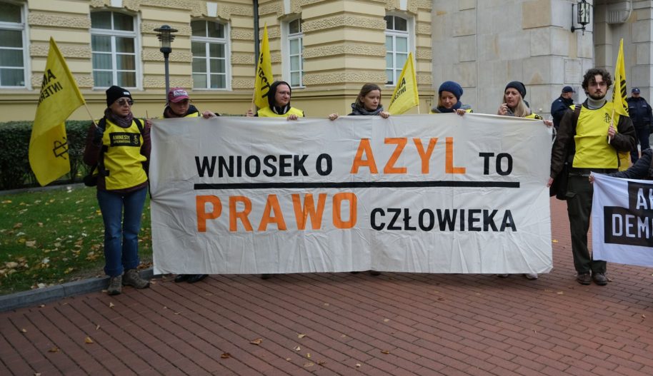 Grupa osób z transparentem przed Kancelarią Premiera.