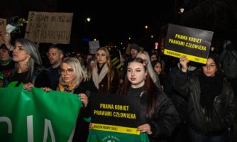 Grupa kobiet z transparentami podczas protestu proaborcyjnego.